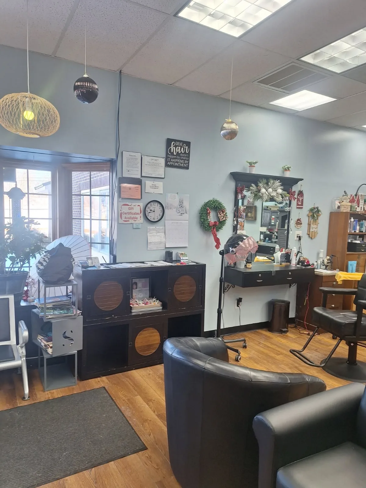 The front desk and a styling station, with gift certificates sign and a framed sign about great hair on the wall